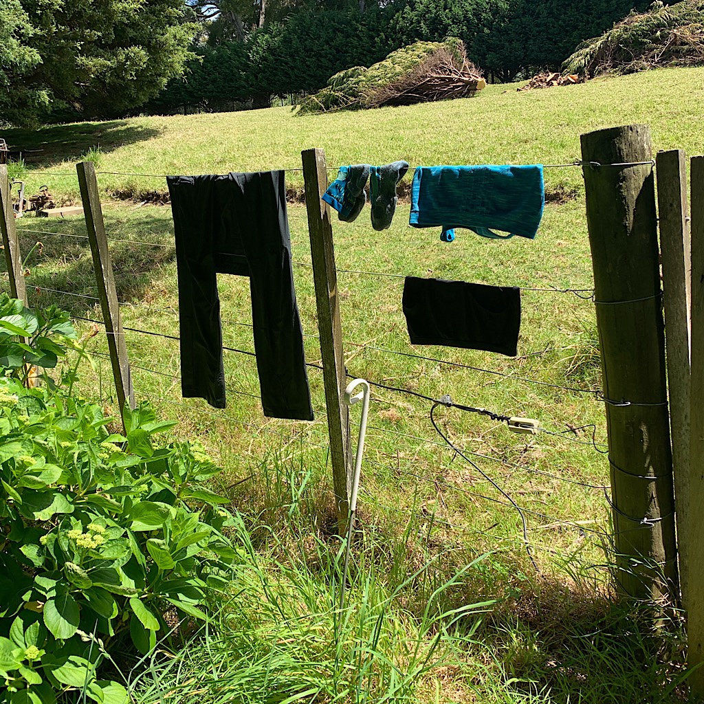 Rinsed hiking clothes drying on the electric fence at Tidesong.