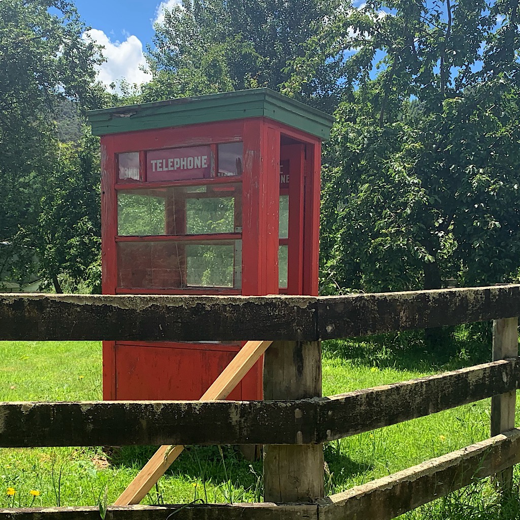 No longer in use but simply a curiosity, this red phone booth sits in a farmer's field. 