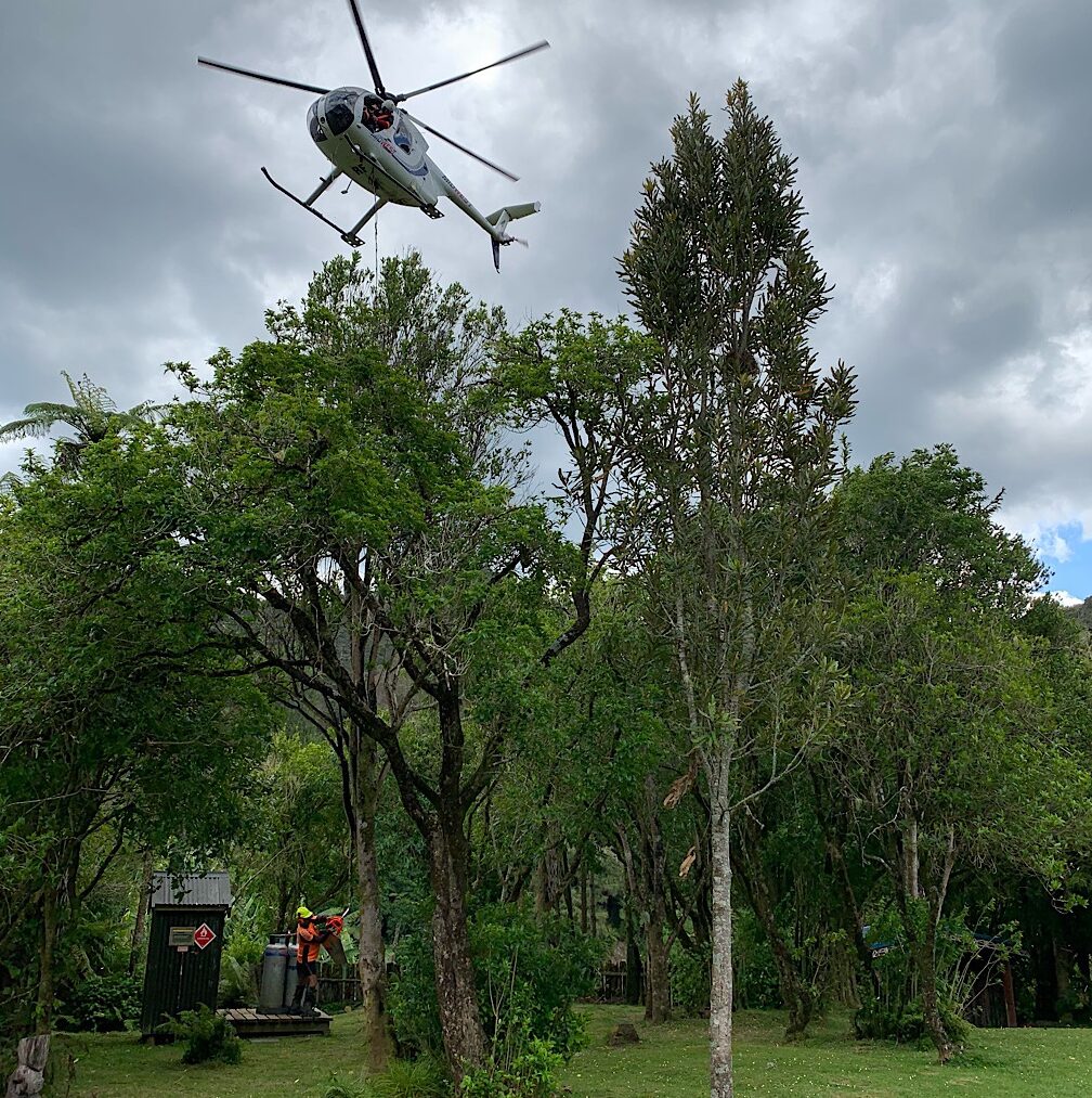 A helicopter delivers goods to the remote community including a riding lawn mower.