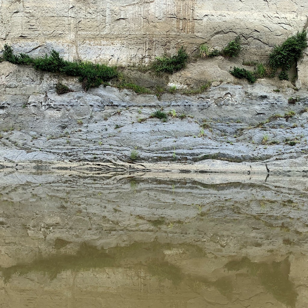Sand and mudstone line the river and look almost as if art made by some early humans, but worn by the river and cascading falls after rains. 