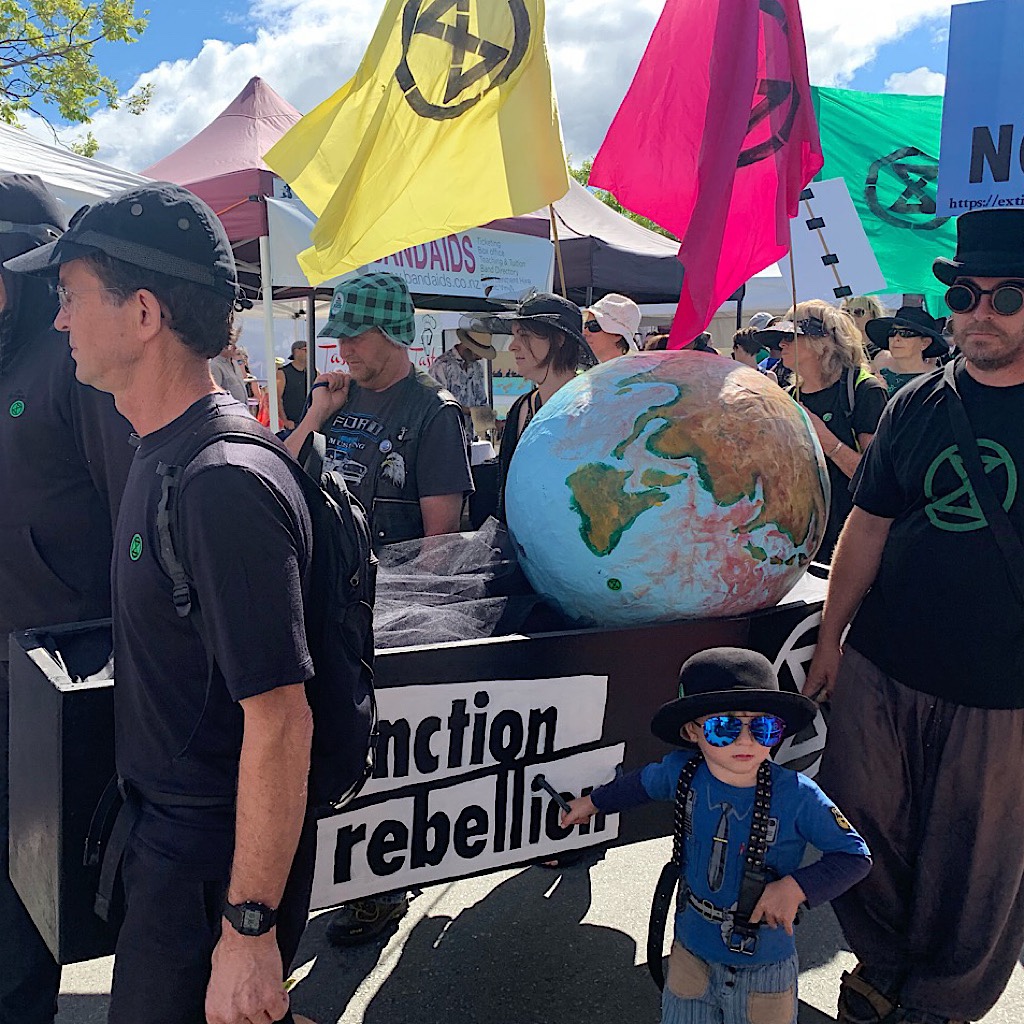 Protesters supporting green energy carrying the earth as pall bearers in the Nelson outdoor market. 