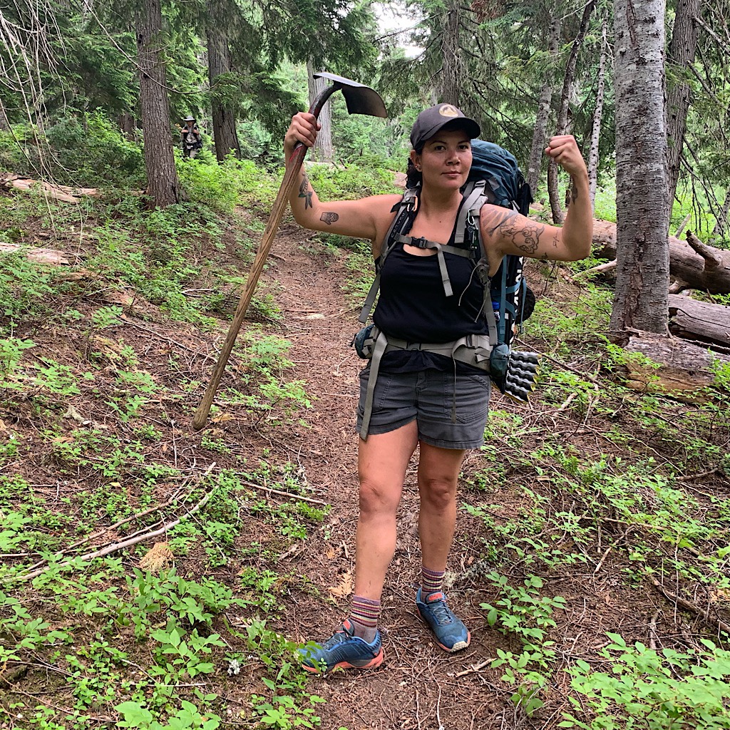 A Pacific Crest Trail worker in the North Cascades shows off her muscles and tatoos. 