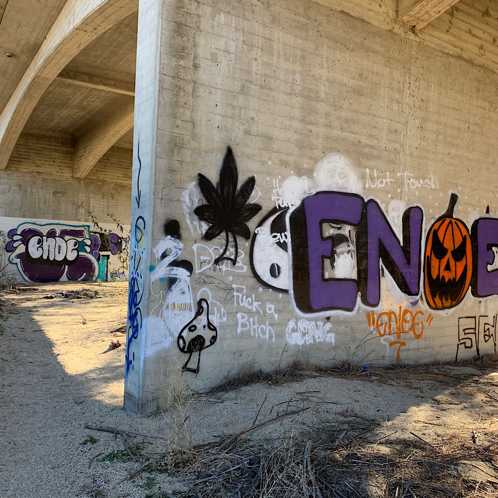 Graffiti artists tag the bridge. 