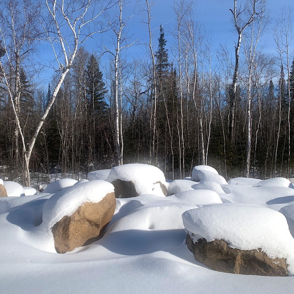 Dazzling layers of snow on huge boulders sparkles in the crisp air. 