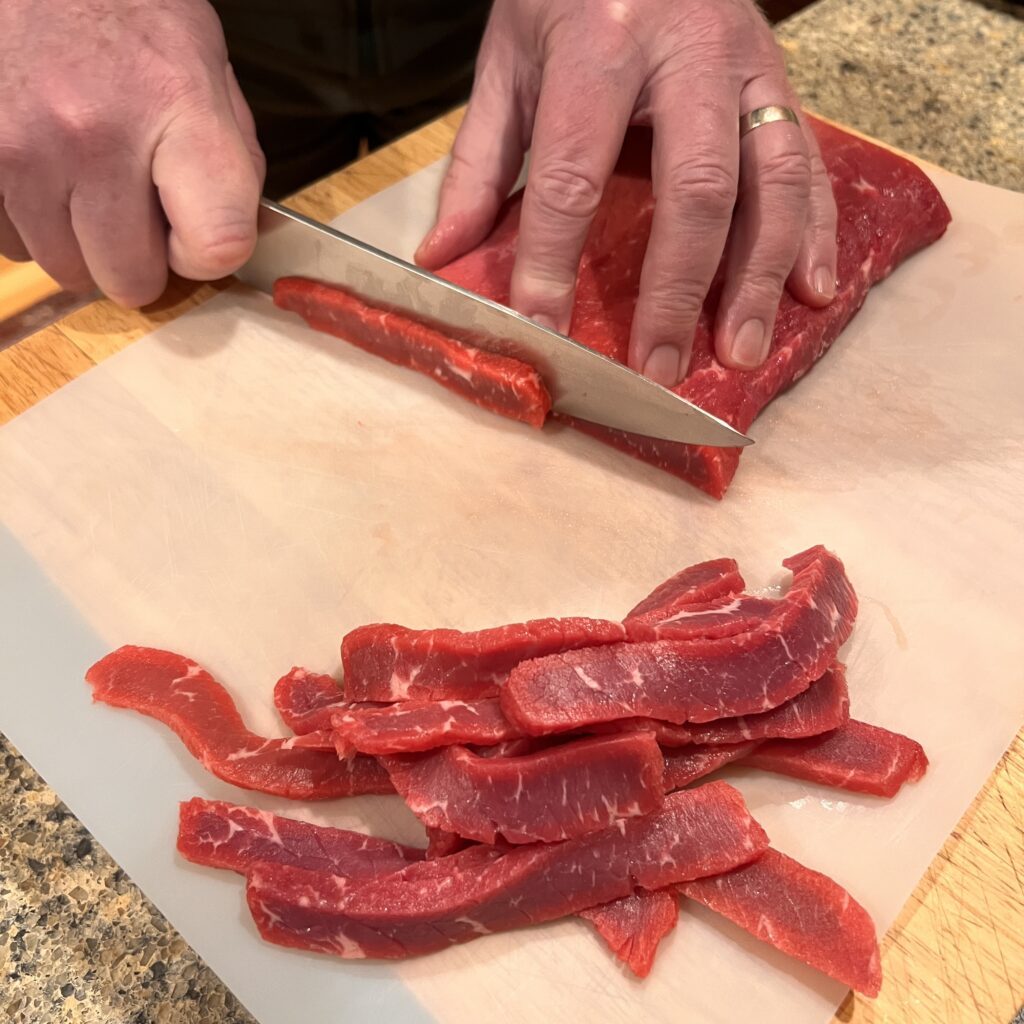 Freeze the meat just to firmness. It makes it easier to slice thinly. 